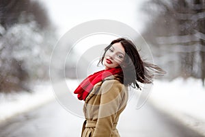 Beautiful brunette with hair blown by wind in the winter