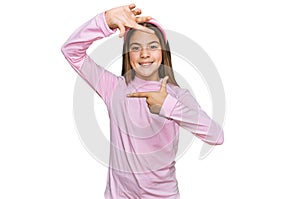 Beautiful brunette little girl wearing casual turtleneck sweater smiling making frame with hands and fingers with happy face