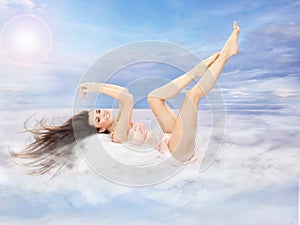 Beautiful brunette lying on clouds