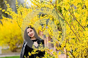 Beautiful brunette near the yellow foliage. Cute beautiful smile woman walking in yellow autumn park. The girl in near the tree