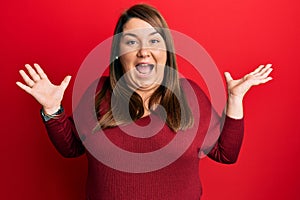 Beautiful brunette plus size woman wearing casual clothes celebrating victory with happy smile and winner expression with raised