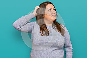 Beautiful brunette plus size woman wearing casual clothes confuse and wondering about question
