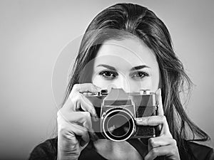 Beautiful brunette pointing vintage camera