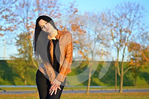 Beautiful brunette posing at colorful autumn park