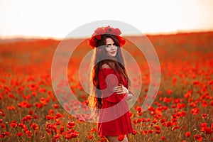 Beautiful brunette in red poppies field. Happy smiling teen girl portrait with wreath on head enjoying in poppy flowers nature bac