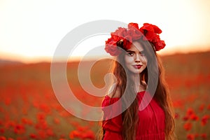 Beautiful brunette in red poppies field. Happy smiling teen girl portrait with wreath on head enjoying in poppy flowers nature