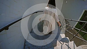 Beautiful brunette runs down on stairs