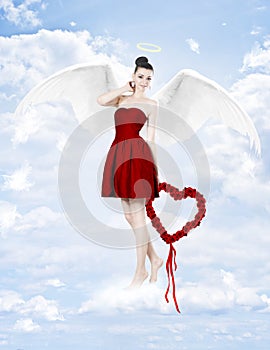 Beautiful brunette woman as cupid with heart made of roses