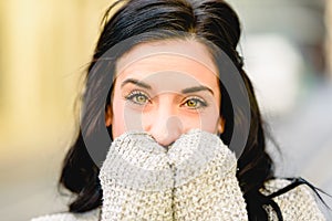 Beautiful brunette woman with beautiful eyes with surprised expression covering her mouth with her hands