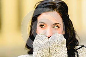 Beautiful brunette woman with beautiful eyes with surprised expression covering her mouth with her hands