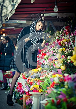 Hermoso morena una mujer en negro sobre el florista la tienda 
