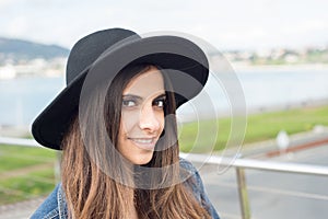 Beautiful brunette woman with a black hat