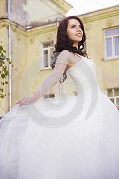 Beautiful brunette woman bride in a garden park in white wedding