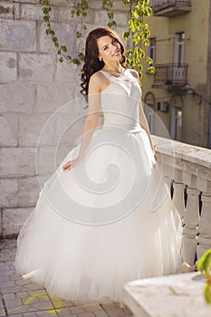 Beautiful brunette woman bride in a garden park in white wedding