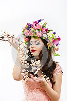 Beautiful brunette woman with a bunch of spring flowers, makeup