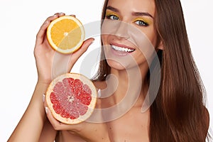 Beautiful brunette woman with citrus on a white background, healthy food, tasty food, organic diet, smile healthy