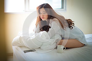 Beautiful brunette woman drinking and morning coffee in bedroom