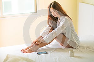 Beautiful brunette woman drinking and morning coffee in bedroom