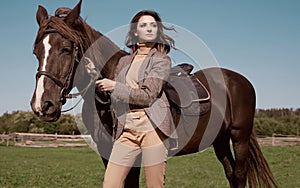 Beautiful brunette woman in an elegant checkered jacket with a horse