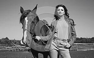 Beautiful brunette woman in an elegant checkered jacket with a horse