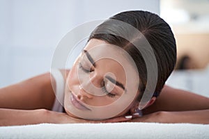 Woman enjoying back massage with closed eyes photo