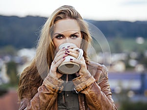 Beautiful brunette woman enjoying coffee outside