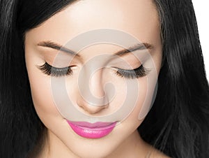 Beautiful brunette woman with eyelashes extension and long brunette curly hairstyle pink lipstick