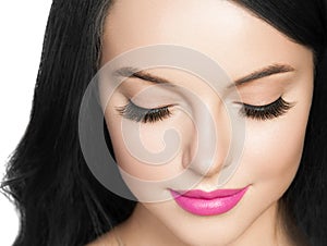 Beautiful brunette woman with eyelashes extension and long brunette curly hairstyle pink lipstick