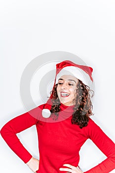 A beautiful brunette woman laughing. She is wearing a red sweater and a Santa hat. Christmas woman portrait concept