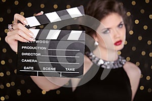 Beautiful brunette woman model holding film clap board cinema