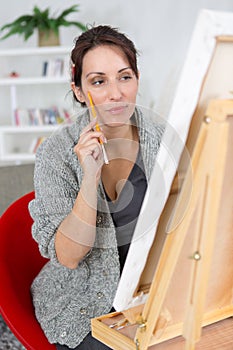 Beautiful brunette woman painting on canva