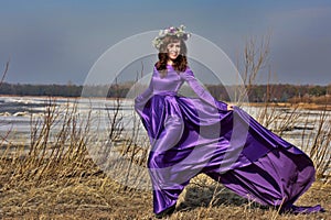 Beautiful brunette woman in purple long dress i