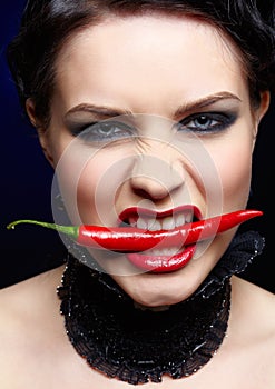 Beautiful brunette woman with red chilli pepper
