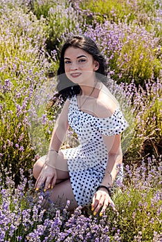 Beautiful brunette woman with red lipstick posing near lavender field