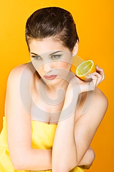 Beautiful brunette woman with slice of lemon