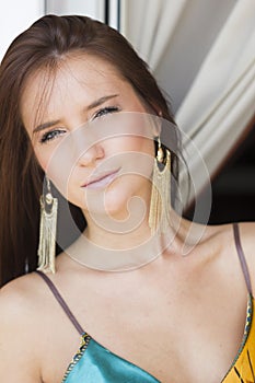 Beautiful brunette woman in summer dress on the balcony