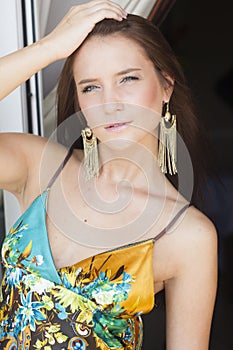 Beautiful brunette woman in summer dress on the balcony