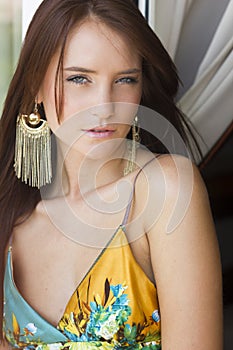 Beautiful brunette woman in summer dress on the balcony