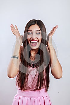 Beautiful brunette woman surprise showing product . Presenting your product. on gray background. Expressive