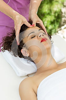 Beautiful brunette woman taking head massage.