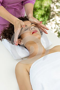 Beautiful brunette woman taking head massage.