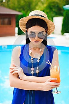 Beautiful brunette woman wearing a blue bikini, enjoying the pool, summer time