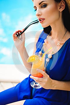 Beautiful brunette woman wearing a blue bikini, enjoying the pool, summer time