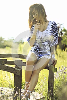 Beautiful brunette woman wearing a blue jumpsuit posing outdoor .