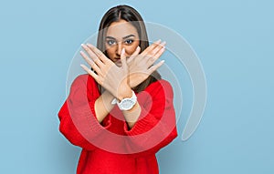 Beautiful brunette woman wearing casual winter sweater rejection expression crossing arms doing negative sign, angry face