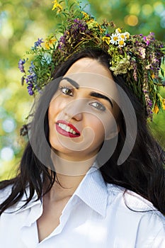 Beautiful brunette woman with a wreath of flowers on head