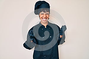 Beautiful brunettte woman wearing professional cook uniform excited for success with arms raised and eyes closed celebrating