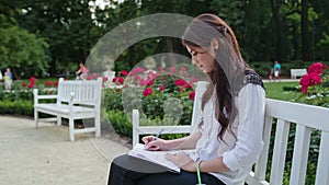 Lady Sitting in the Park and Writing