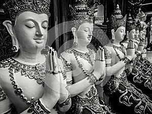 Beautiful buddhist sculpture hands clasped in prayer, detail of buddhist figures carved in Wat Sanpayangluang at Lamphun, Thailand