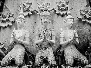 Beautiful buddhist sculpture hands clasped in prayer, detail of buddhist figures carved in Wat Sanpayangluang at Lamphun, Thailand